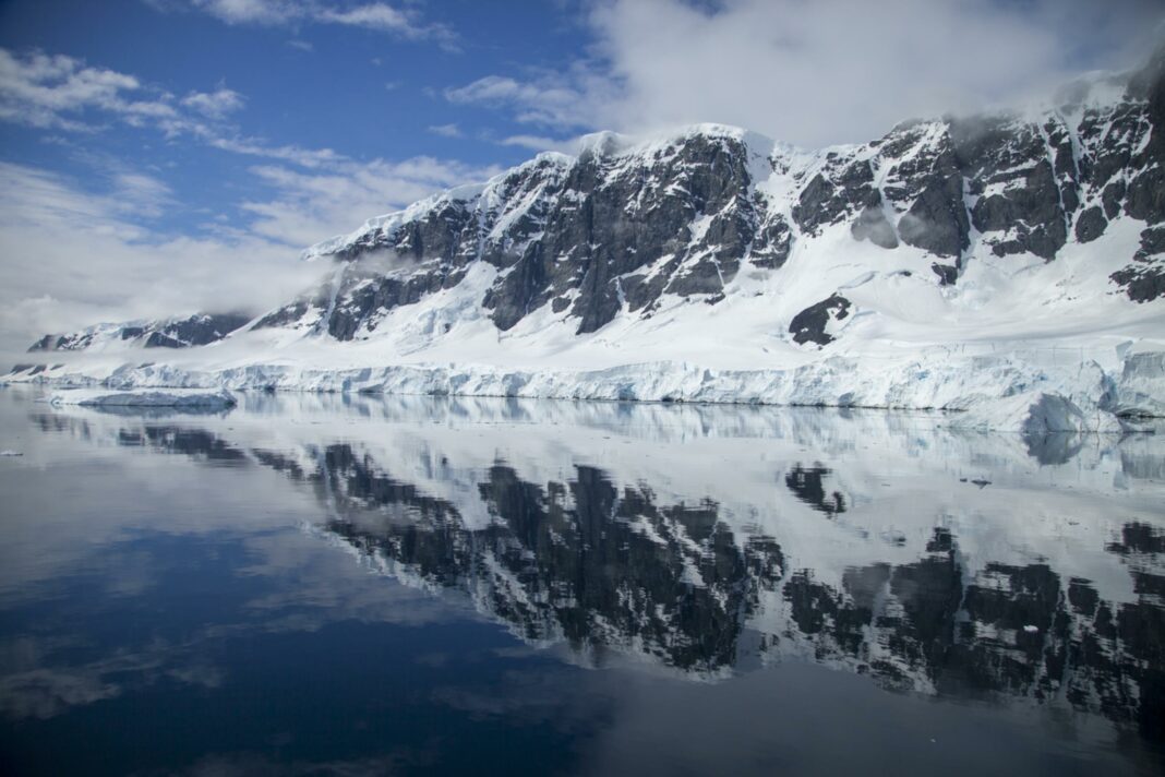 reflection of snow covered mountain in antarctica