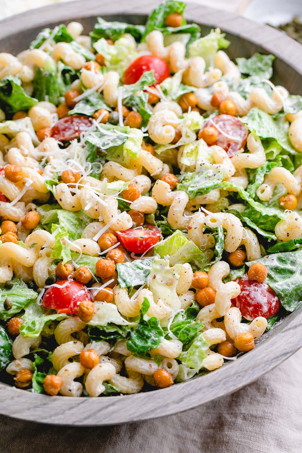 side angle view of serving bowl with healthy vegan caesar pasta salad.