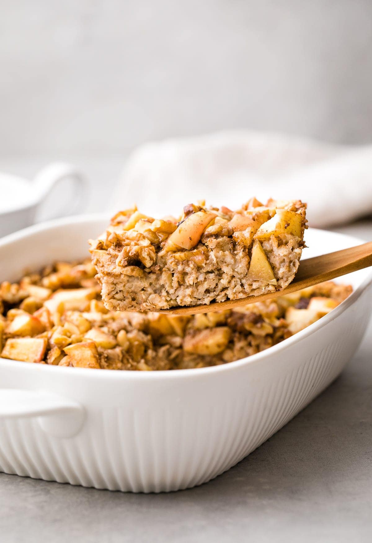 head on view of slice of apple baked oatmeal on wooden spatula.