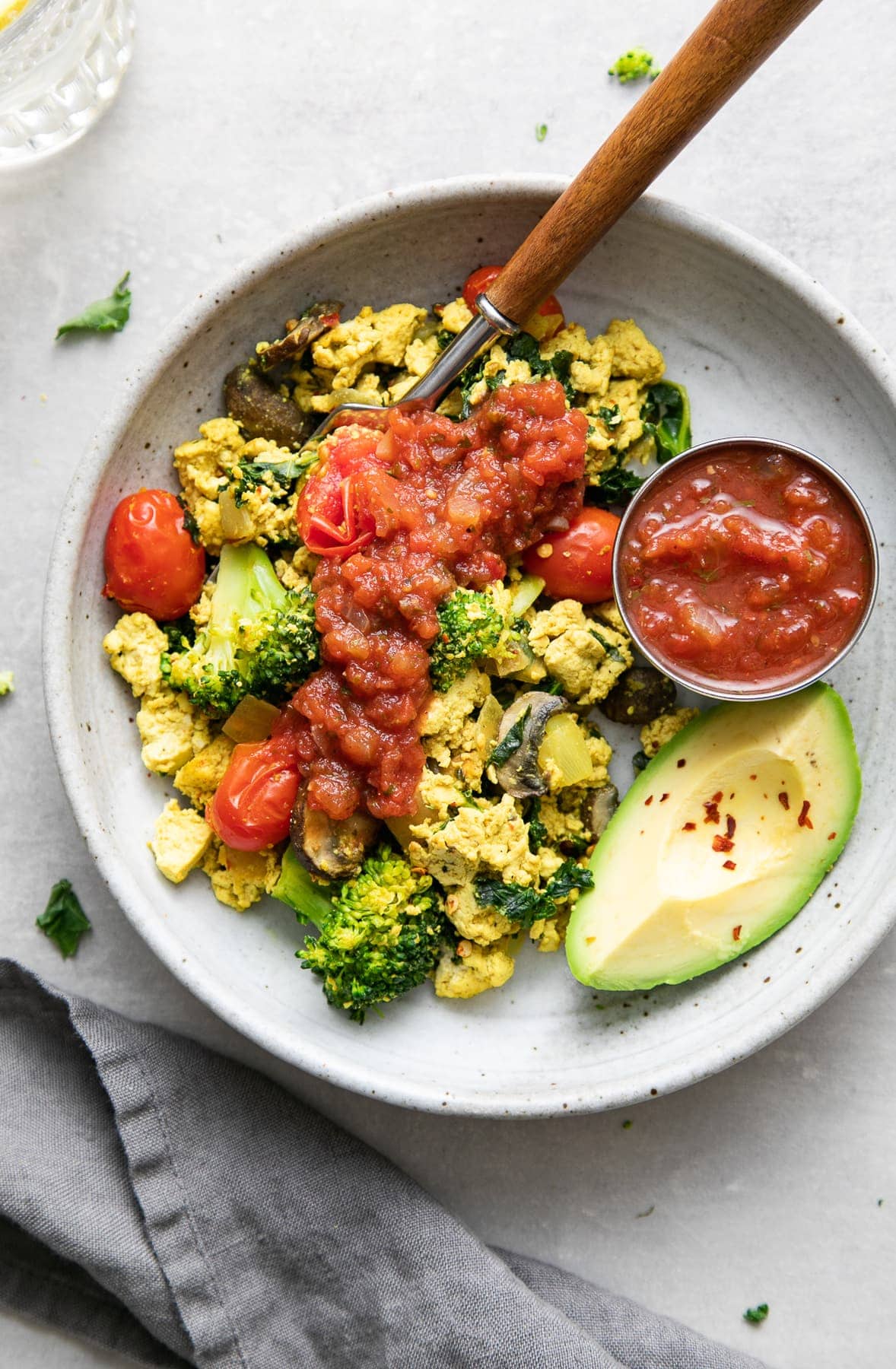 top down view of a bowl with a serving of southwest tofu scramble with items surrounding.