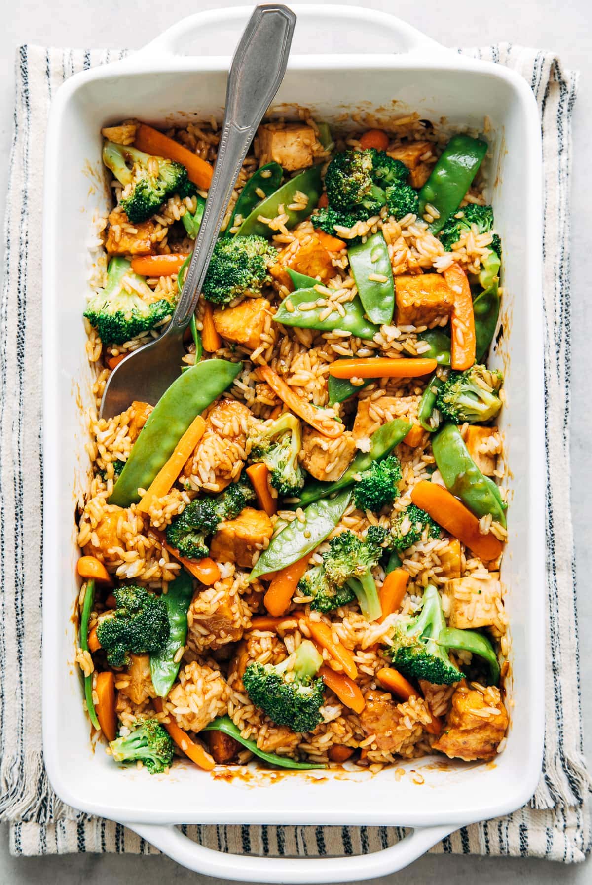 top down view of freshly made teriyaki tofu tempeh casserole in baking dish.