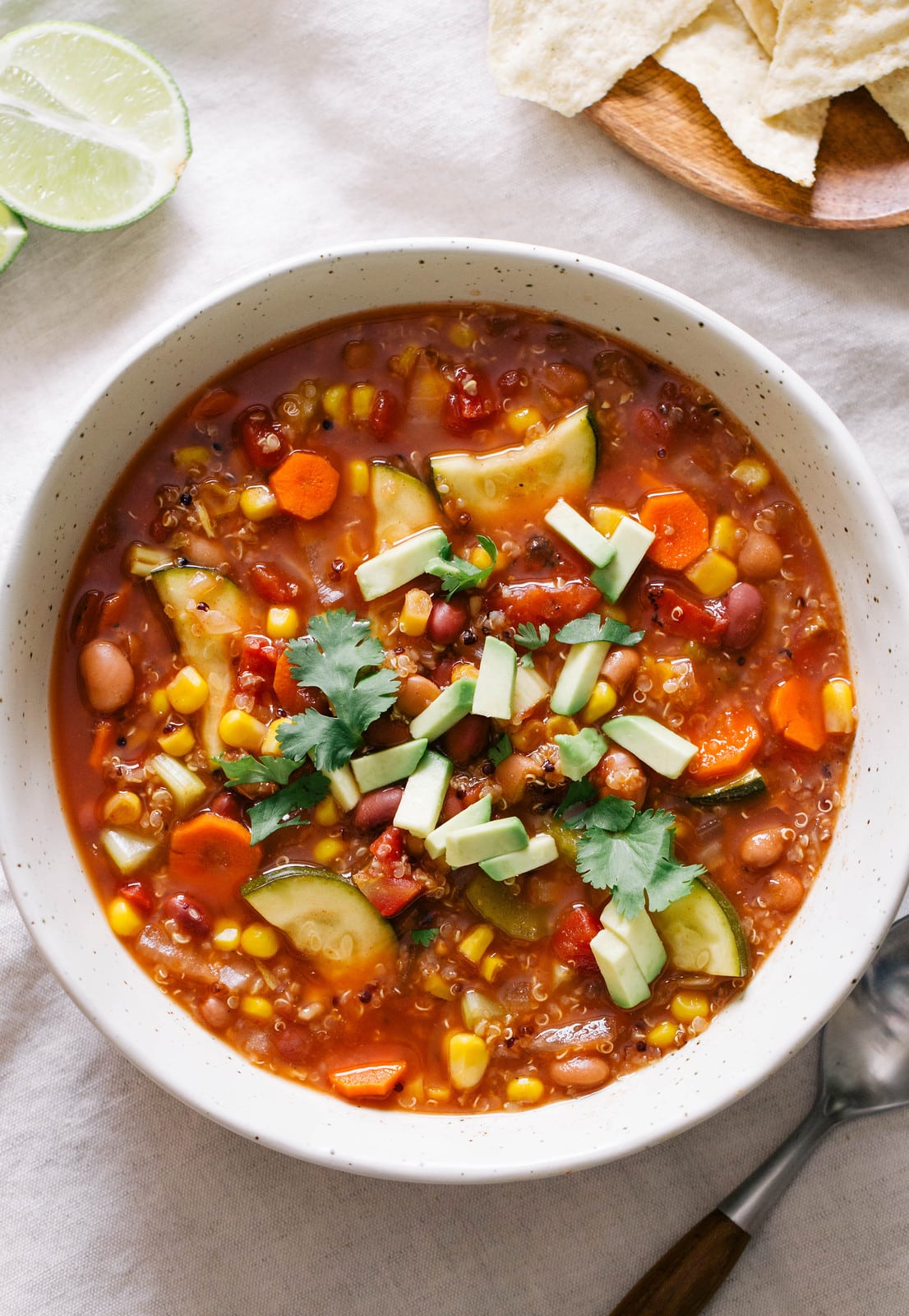 top down view of soup full of tex mex quinoa vegetable soup with items surrounding.