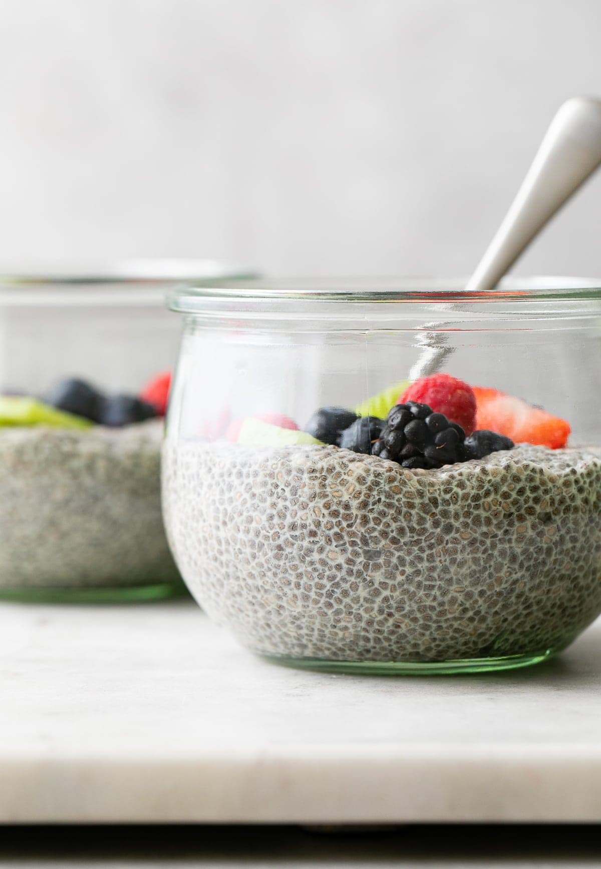 head on view of jar with vanilla chia pudding with fruit and spoon.