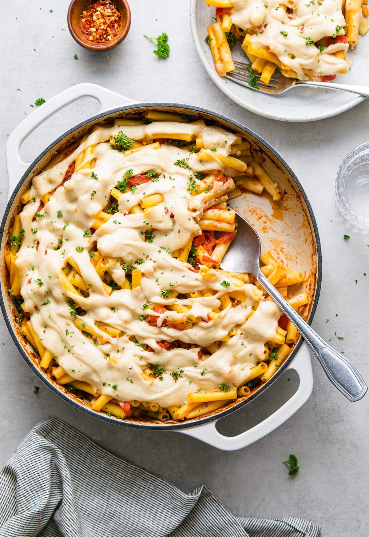 top down view of freshly made vegan baked ziti with items surrounding.