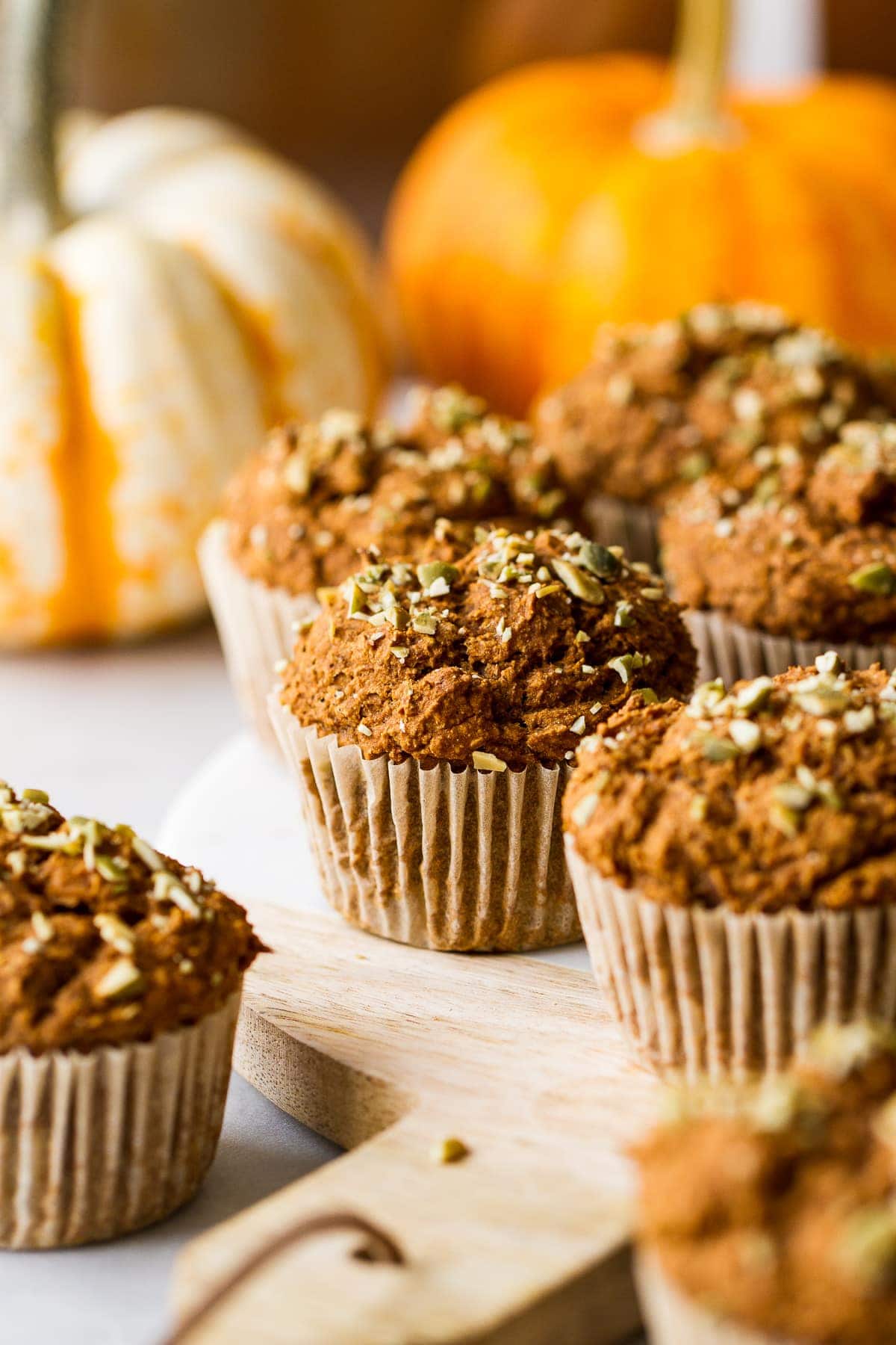 head of view of freshly made vegan pumpkin muffins resting on a serving board.