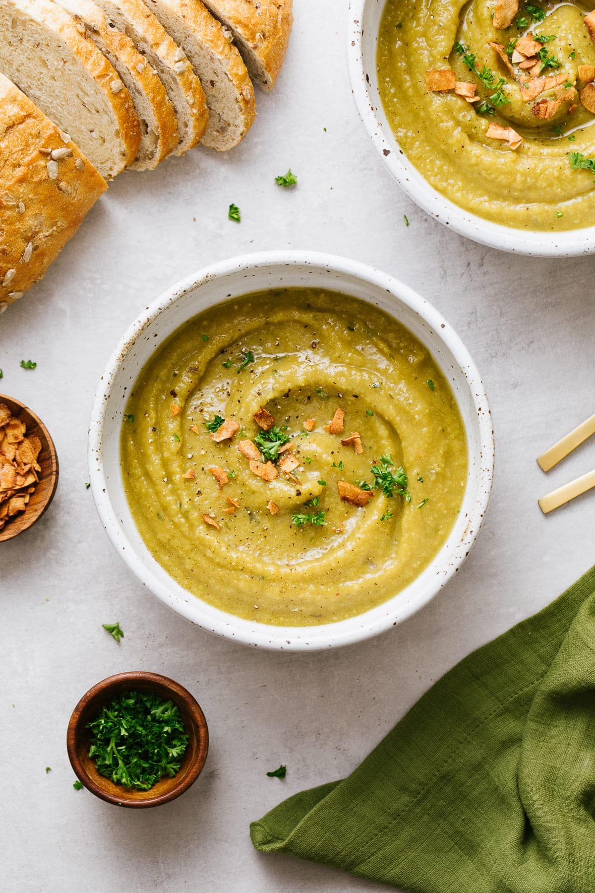 top down view of bowl of healthy vegan split pea soup with items surrounding.