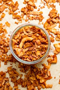 top down view of freshly made coconut bacon in a glass mason jar.