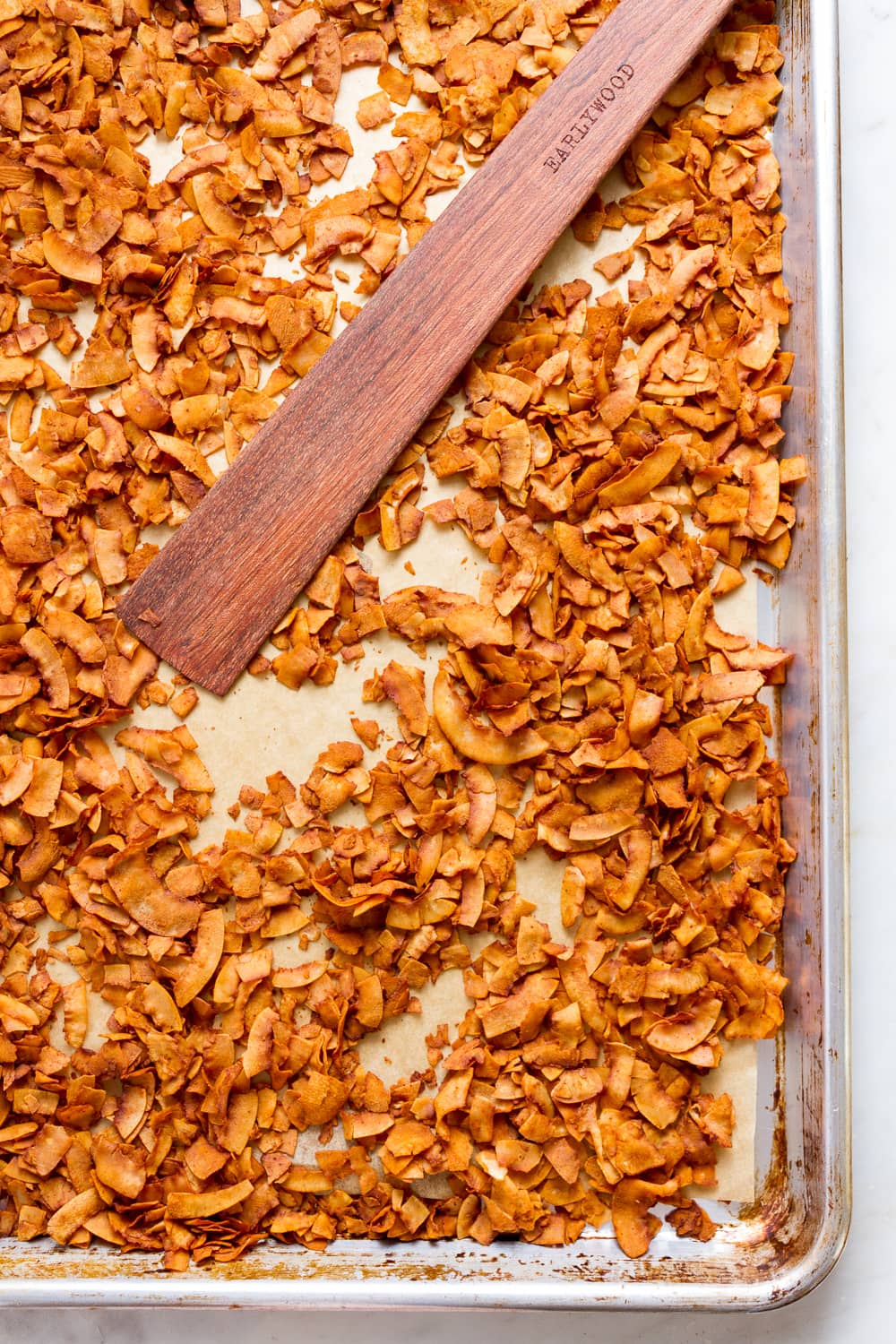 top down view of coconut bacon on rimmed baking sheet just pulled from the oven.