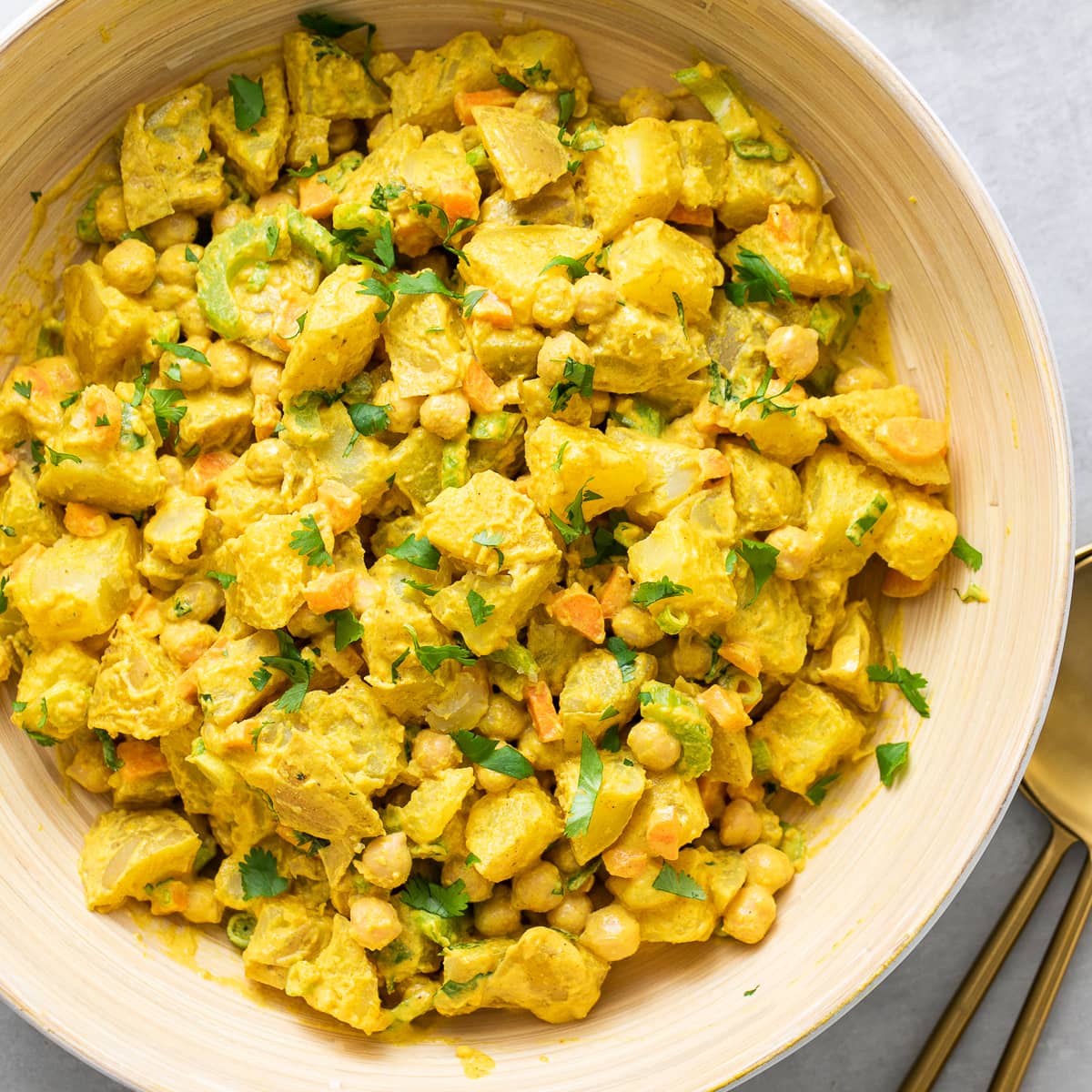 top down view of curried potato salad in large serving bowl.