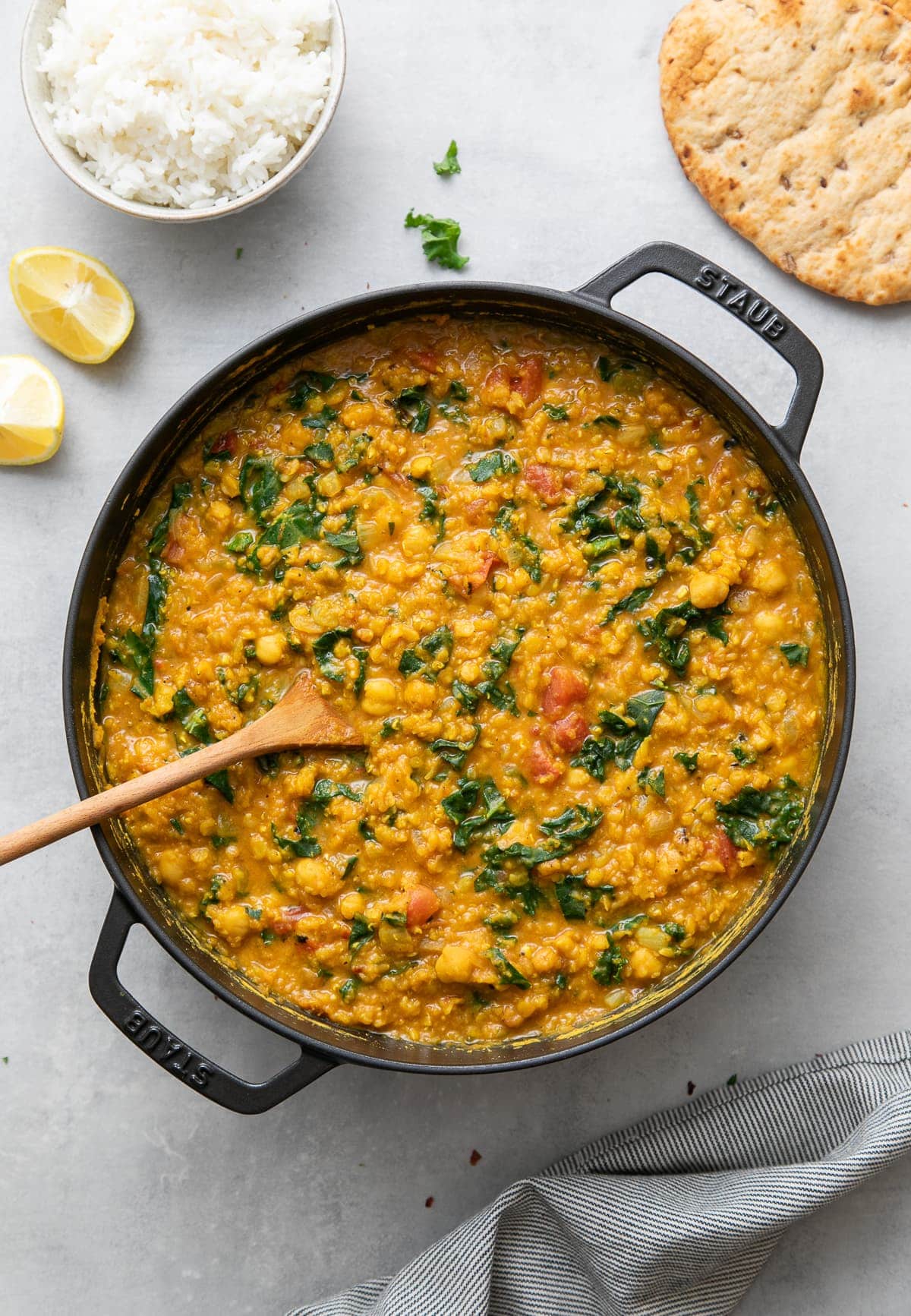 top down view of freshly made pot of curry red lentil stew with chickpea and kale.