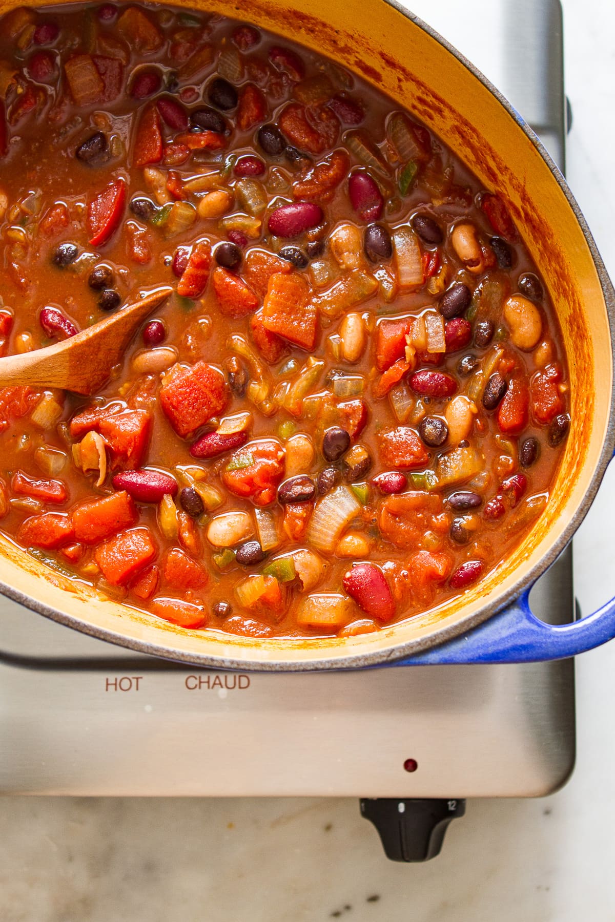 top down view of freshly cooked easy three bean chili in a dutch oven on the stovetop.