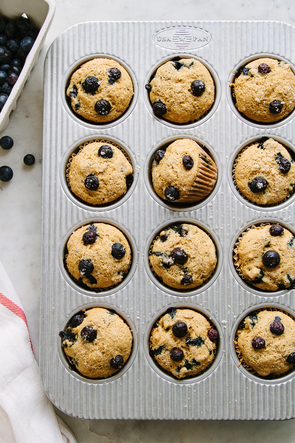 top down view of vegan blueberry muffins in a muffin tin just pulled from the oven.