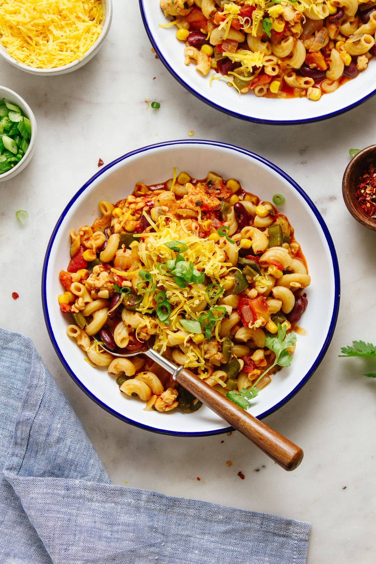 top down view of a serving of vegan chili mac in a white bowl with blue rim.