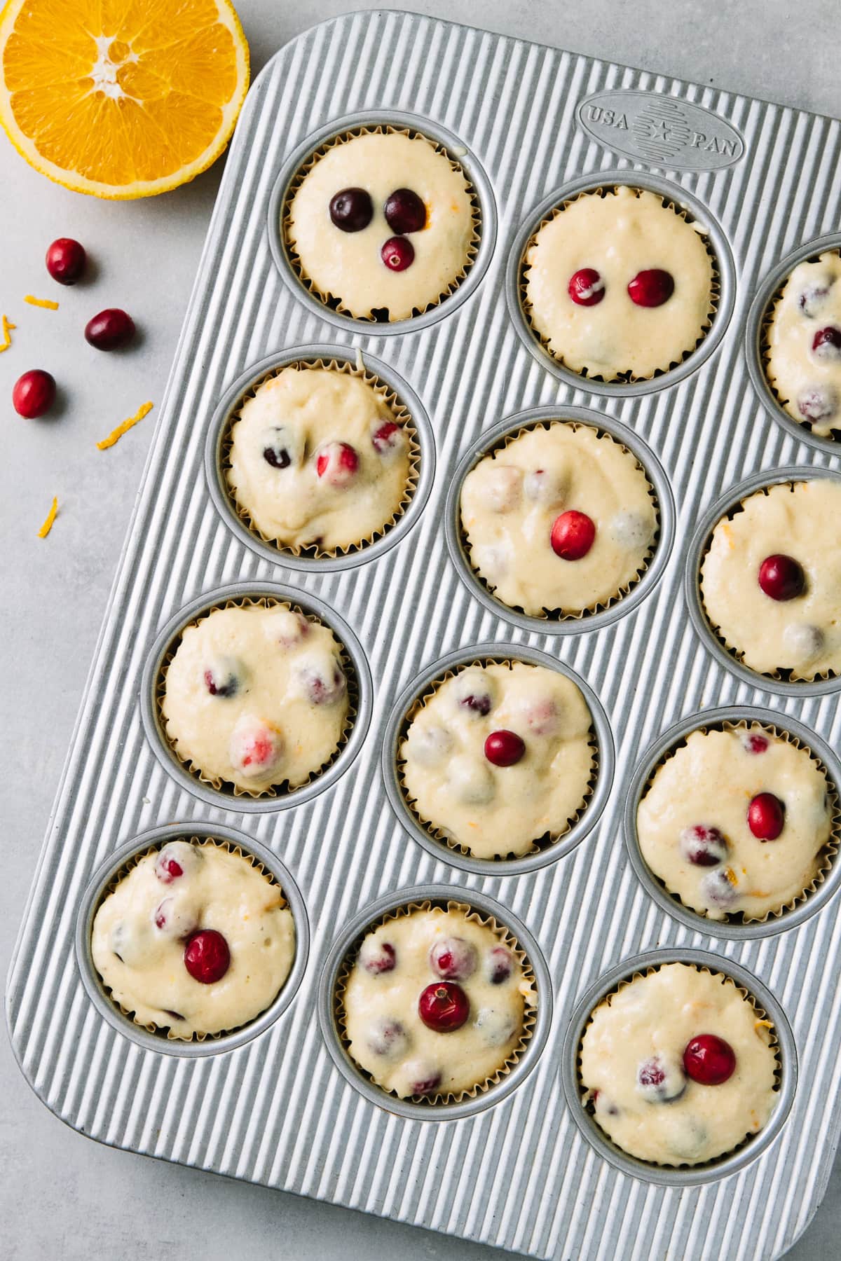 top down view of cranberry orange muffin batter in muffin tin and ready to bake.