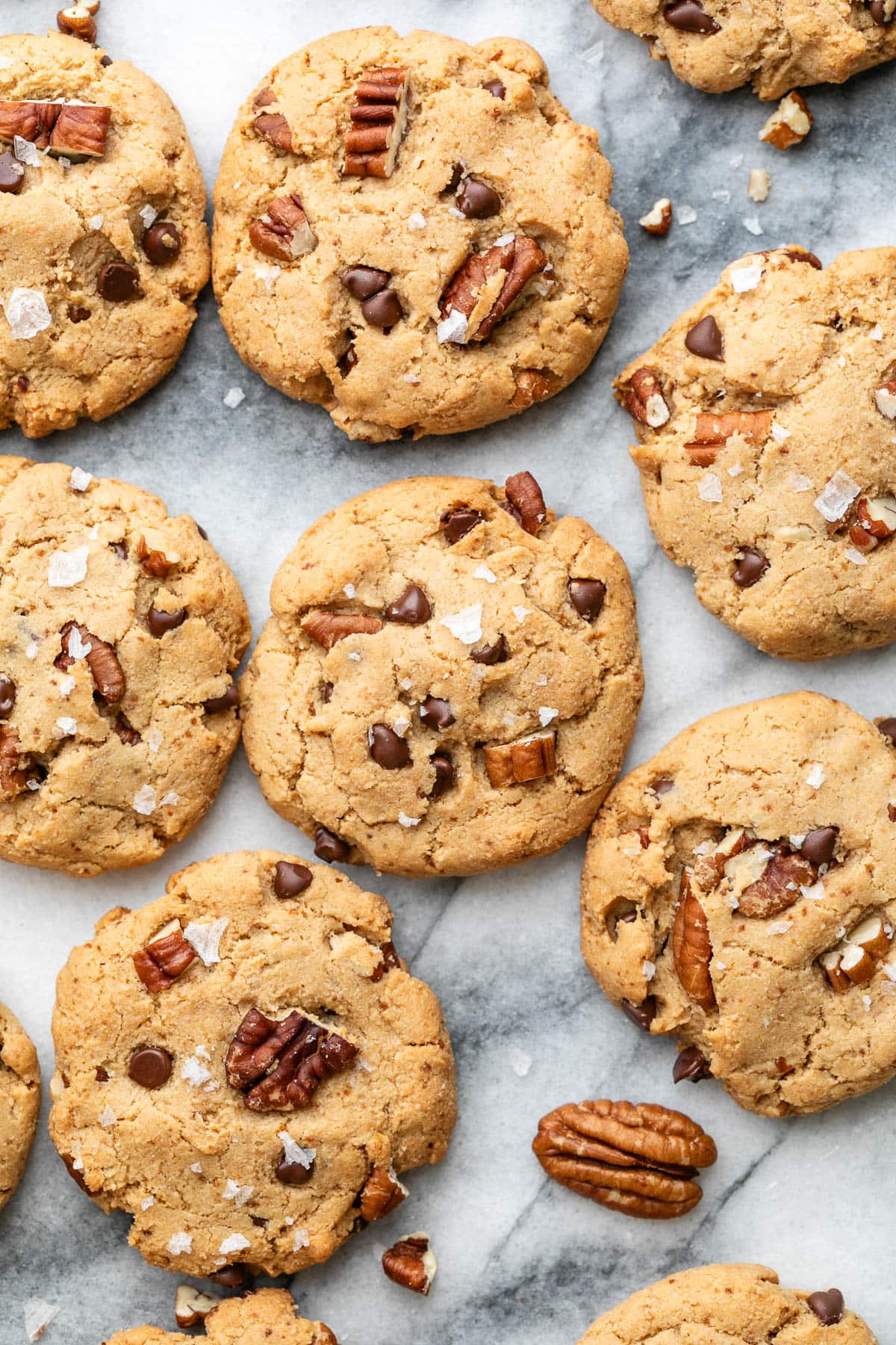 top down view of almond flour pecan sandies arranged on a marble slab.