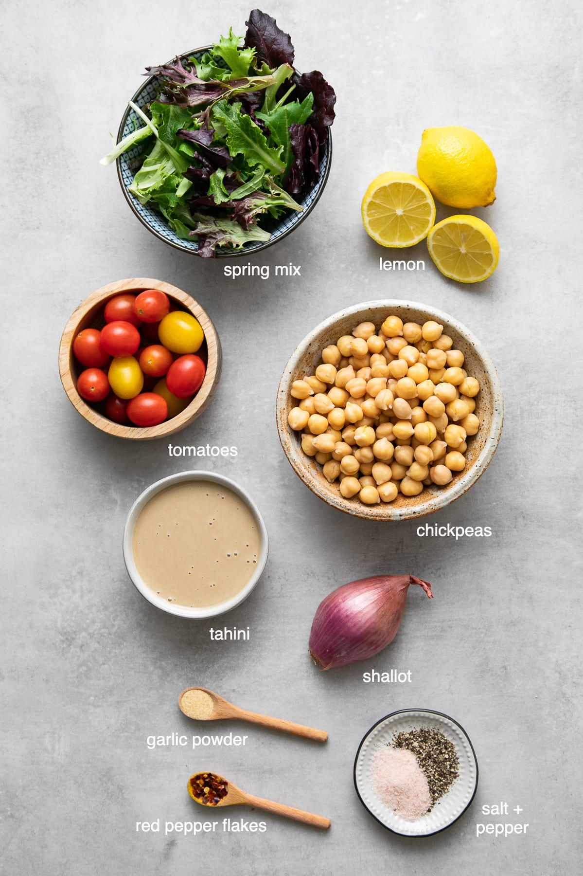 top down view of ingredients used to make green salad with chickpeas and tahini dressing.