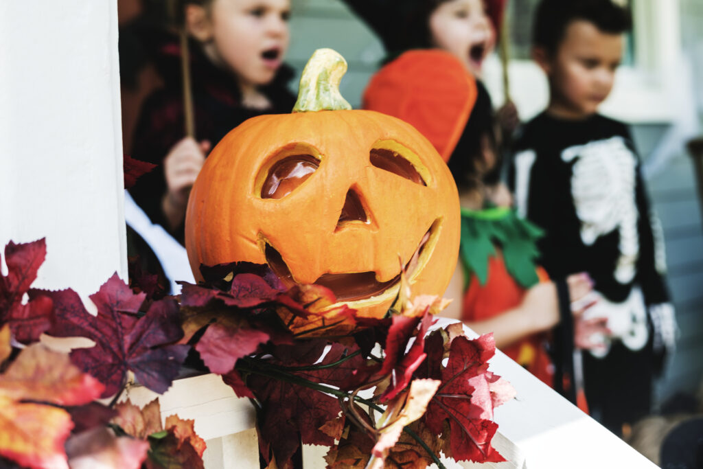 jack o lantern on banister with fall leaves 