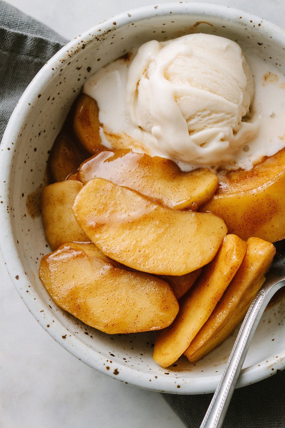 warm spiced cinnamon apples in a bowl with non-dairy vanilla ice cream