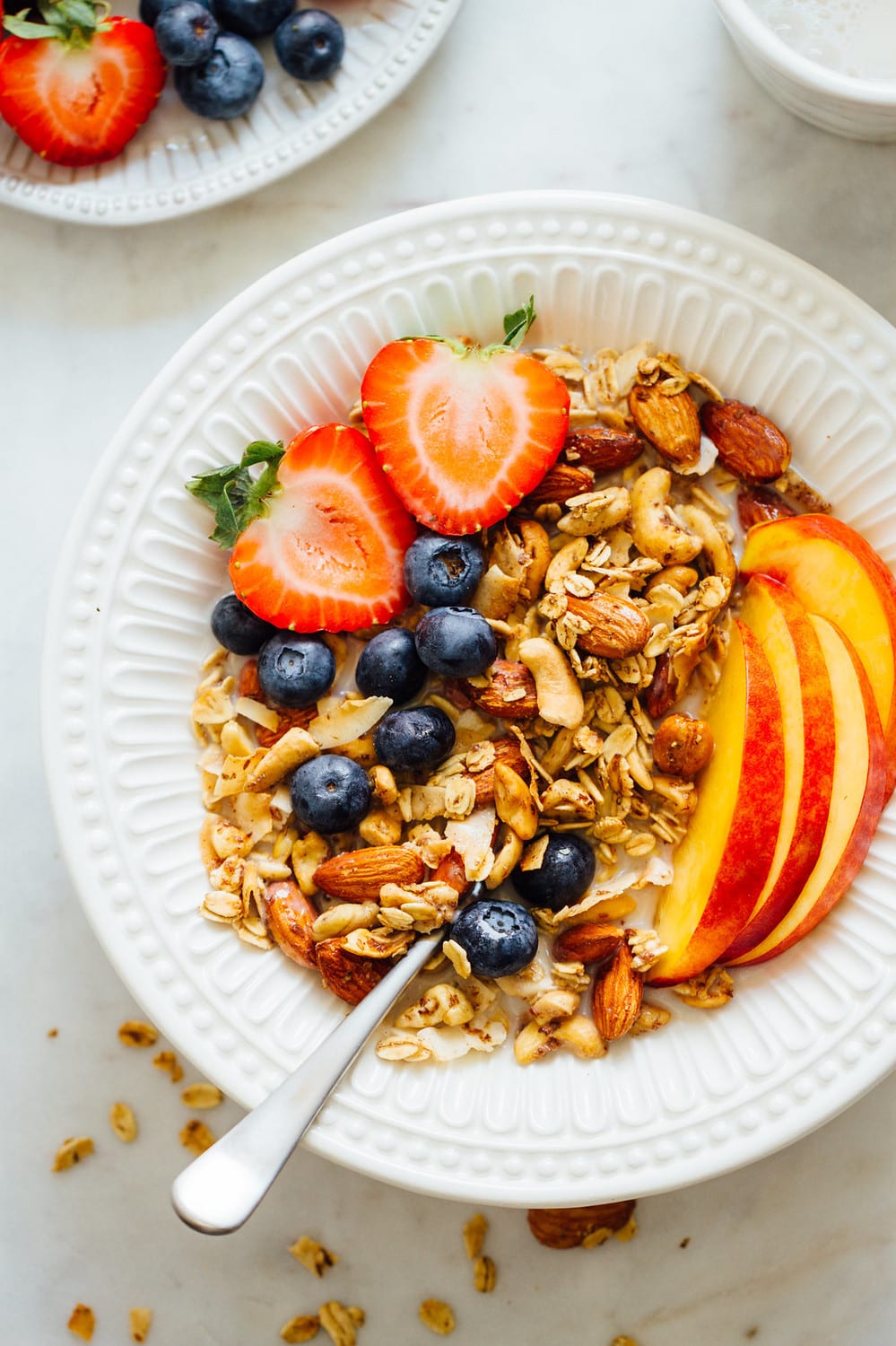 bowl of granola with fresh sliced fruit and non dairy milk