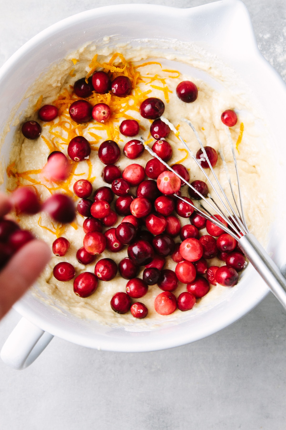 top down view showing the process of making healthy cranberry orange muffin batter.