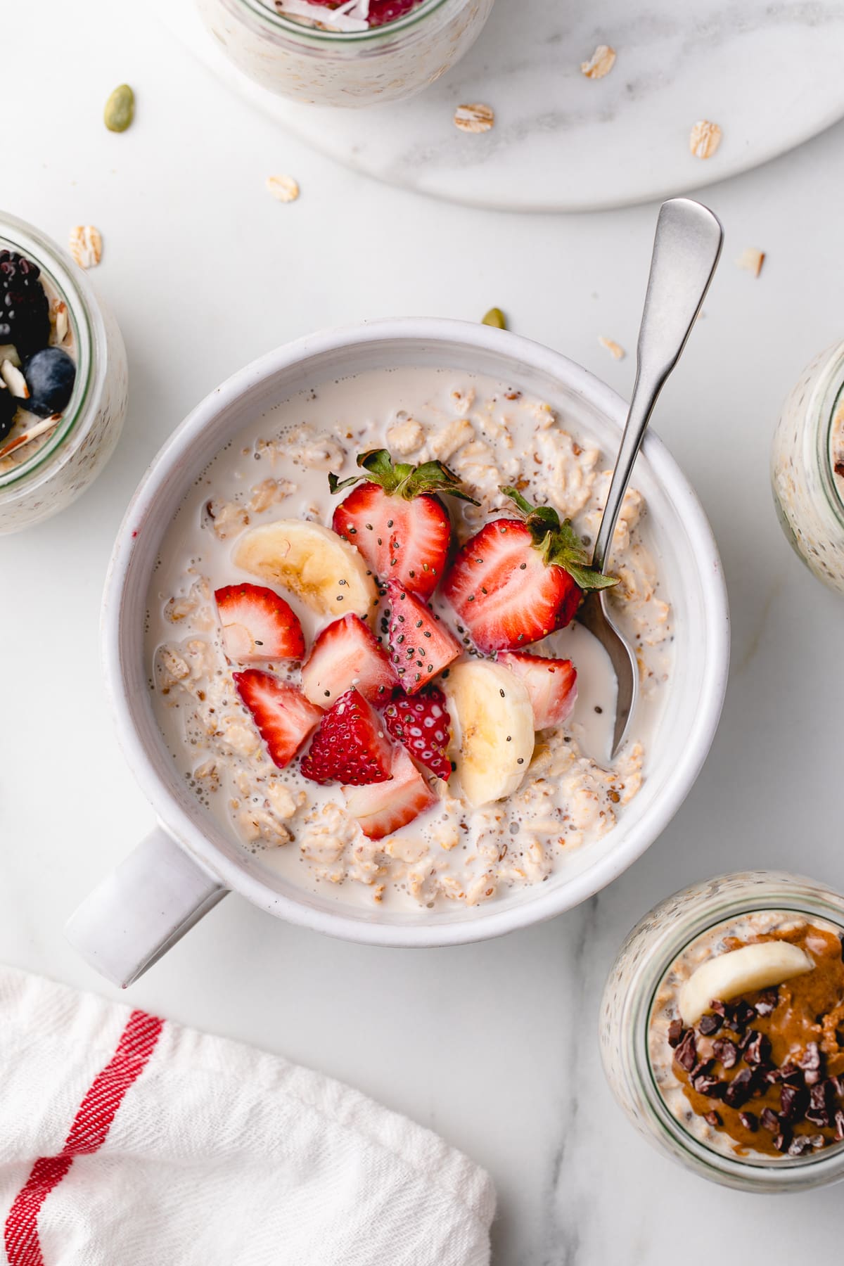 top down view of bowl with overnight oats and berries with items surrounding.