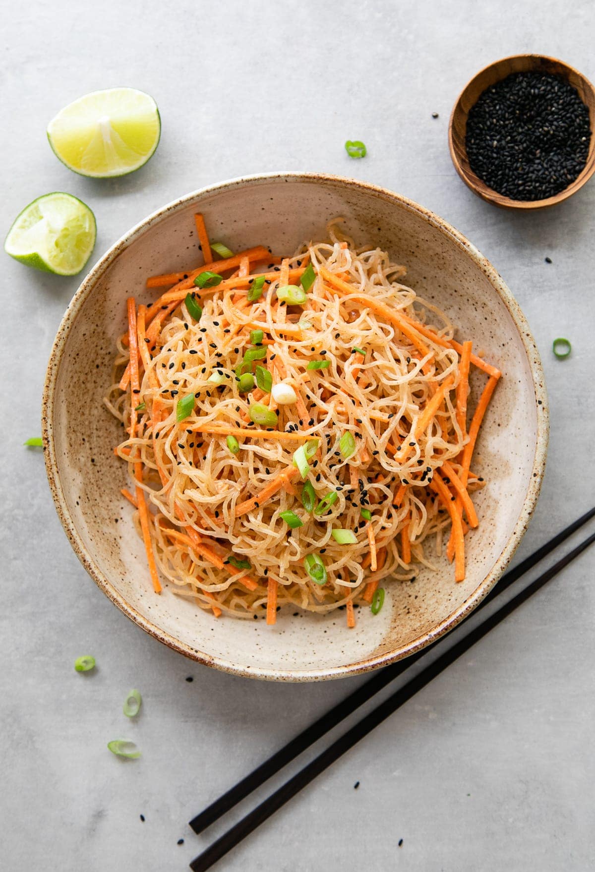 top down view of serving of kelp noodle salad in bowl with items surrounding.