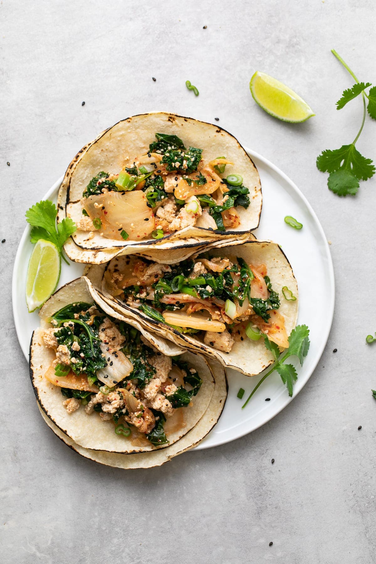 top down view of a small white plate with kimchi tofu scramble tacos.