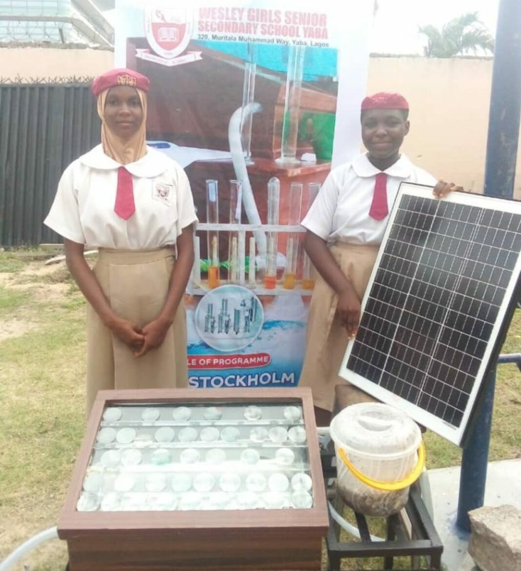 young girls behind a water filter device