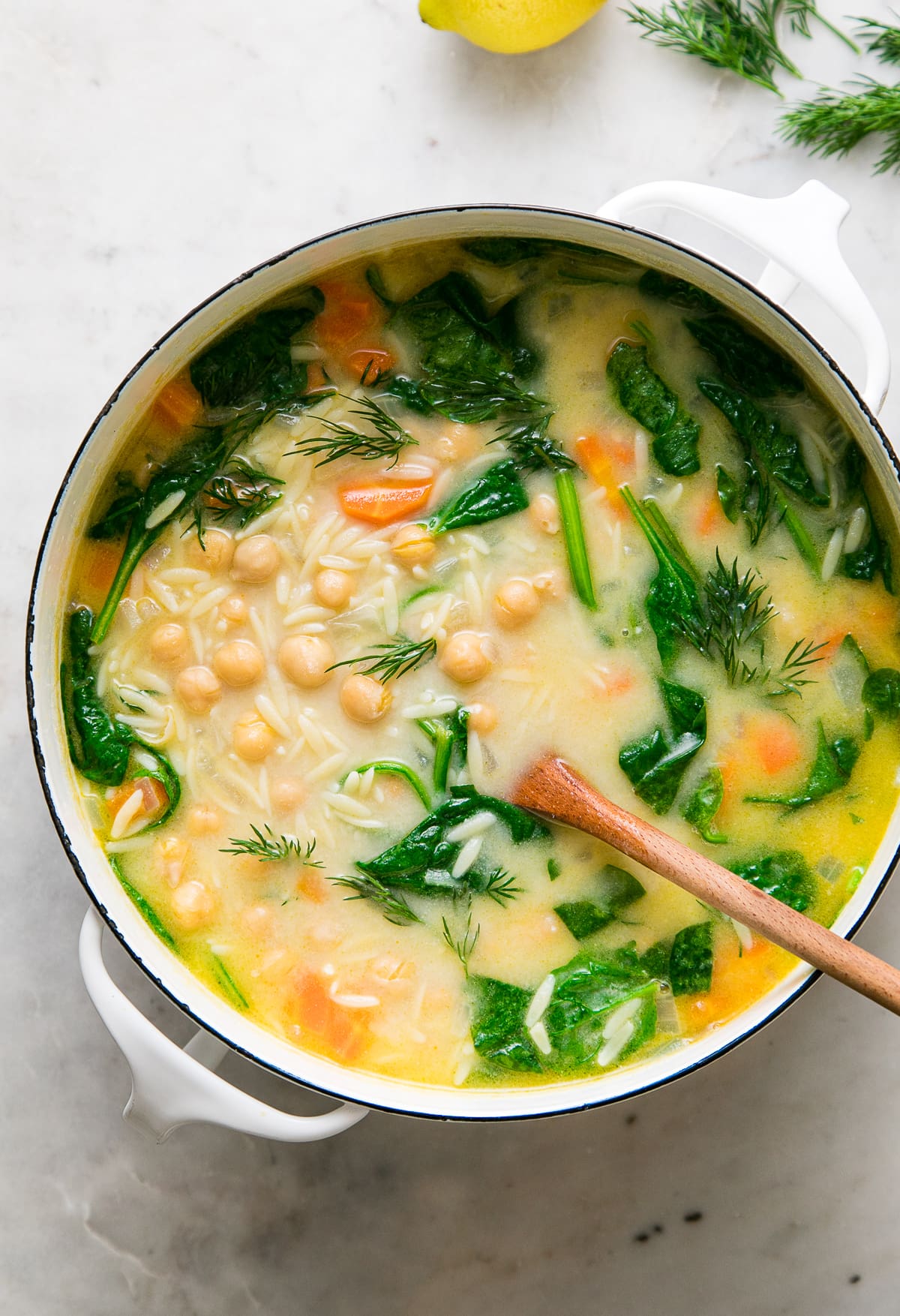 top down view of healthy chickpea lemon orzo soup in large pot.