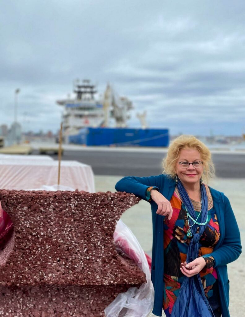 melody brenna with arm on oceanite block with ship