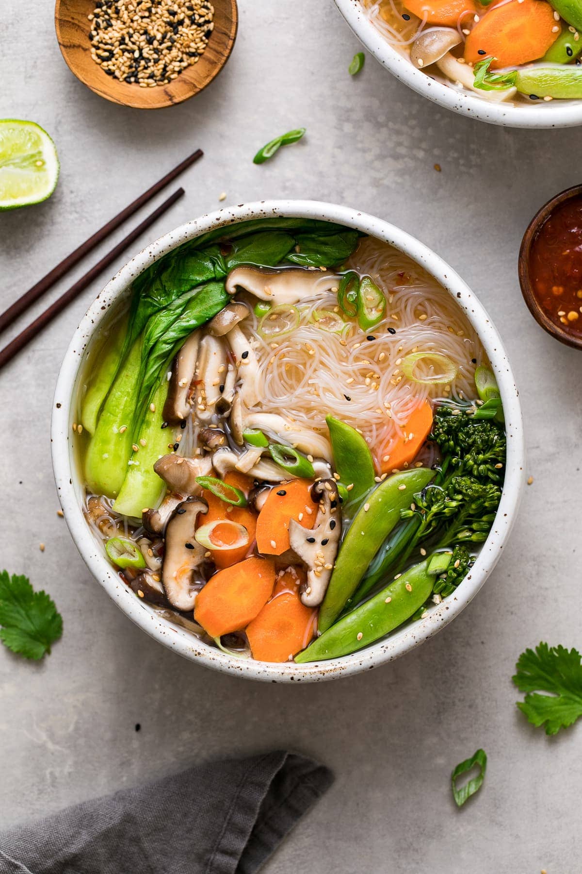 top down view of vegan miso noodle bowl with veggies and items surrounding.