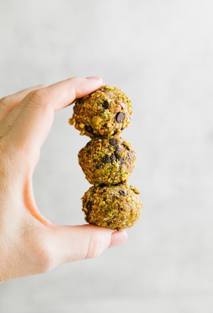 head on shot of fingers holding 3 no bake cookie balls.