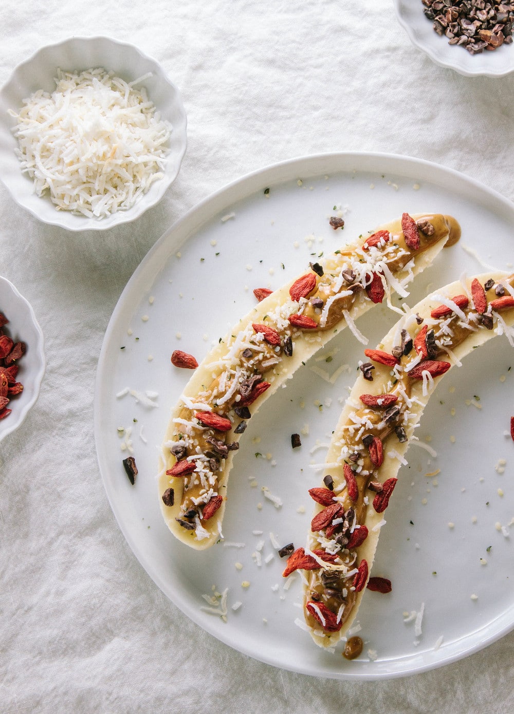 top down view of healthy banana boats on a small white plate.