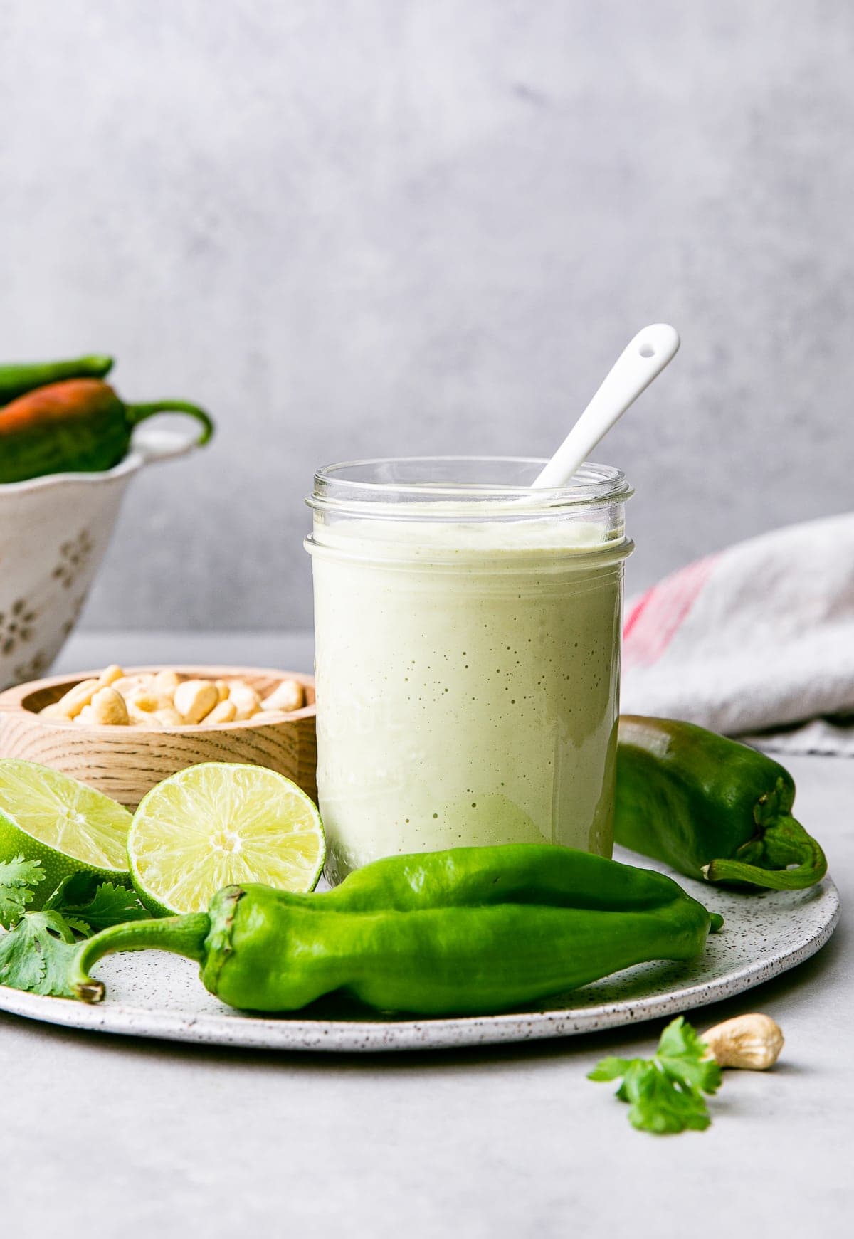 head on view of mason jar with creamy hatch chile dressing and items surrounding.