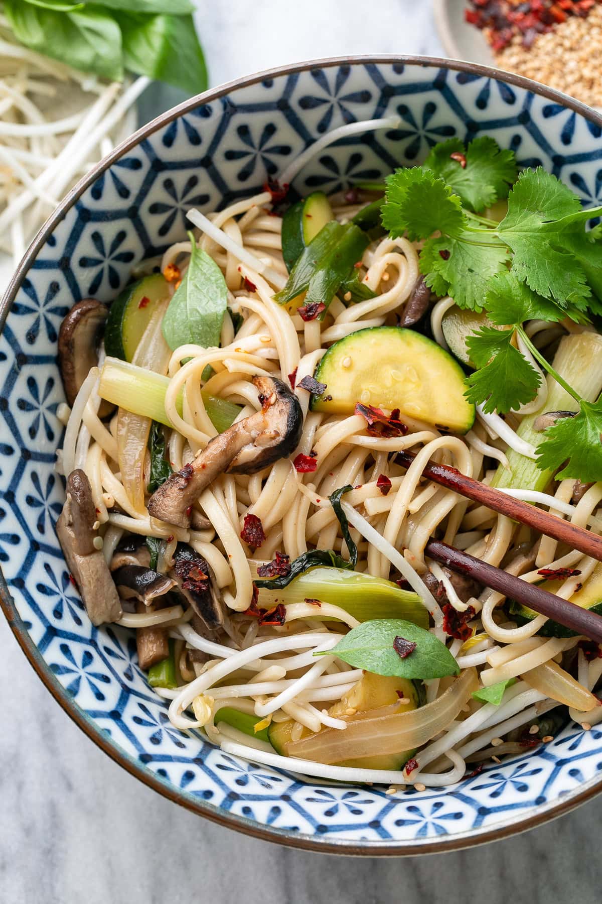 top down view of plated udon noodle bowl with items surrounding.