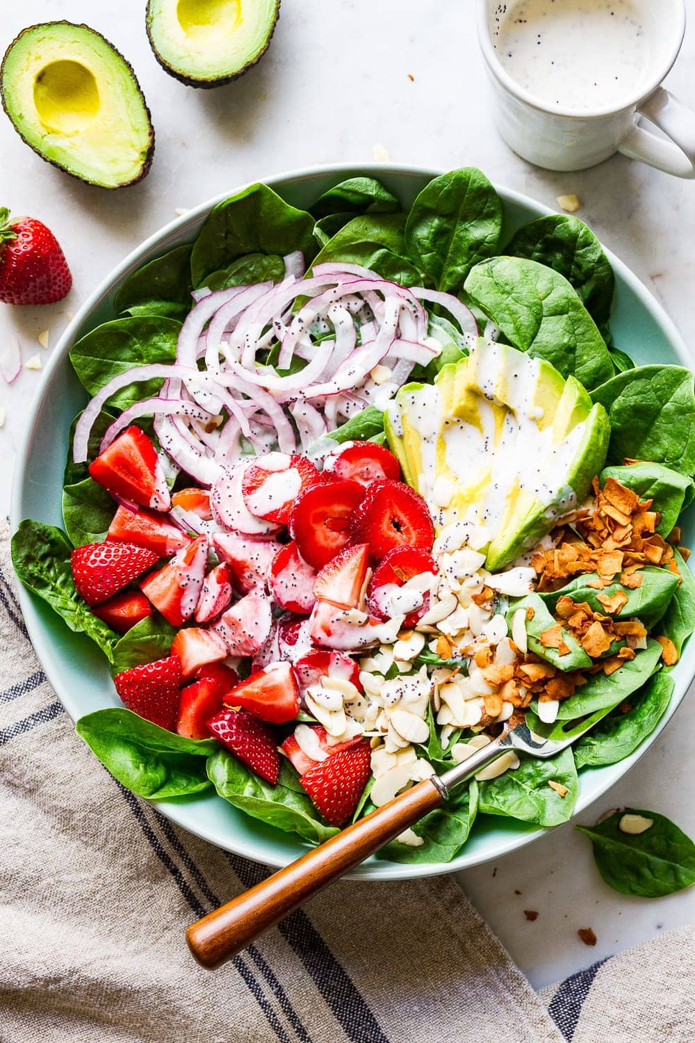 top down view of strawberry spinach salad with avocado.