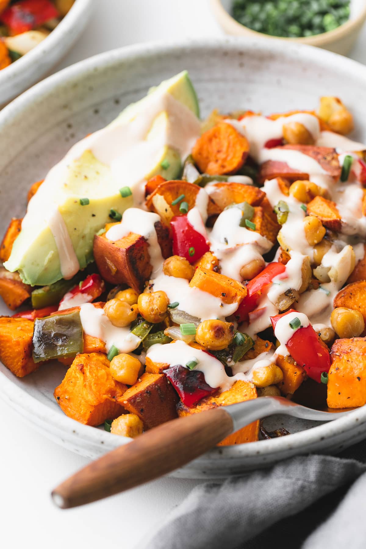 side angle view of plated sweet potato breakfast hash with items surrounding.