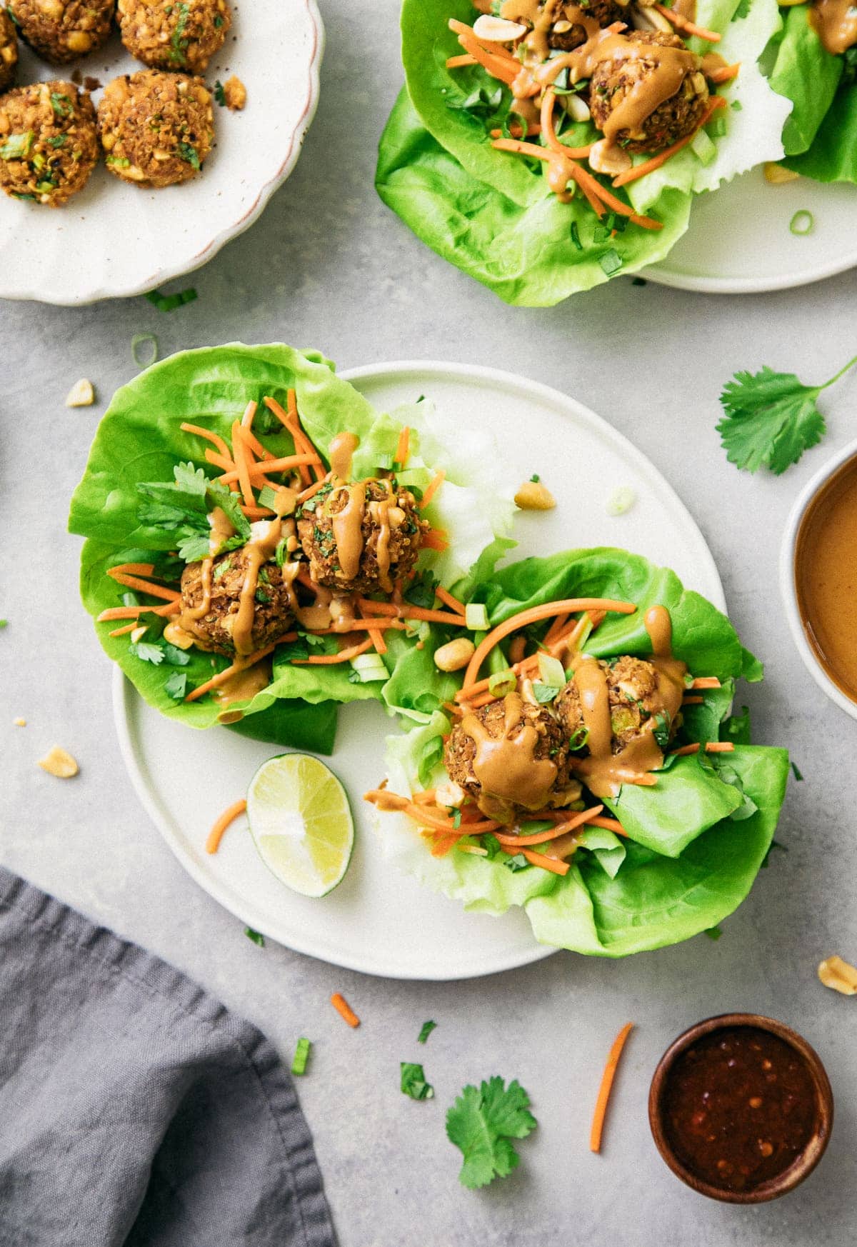 top down view of vegan lettuce wraps with thai quinoa meatballs on a plate with items surrounding.