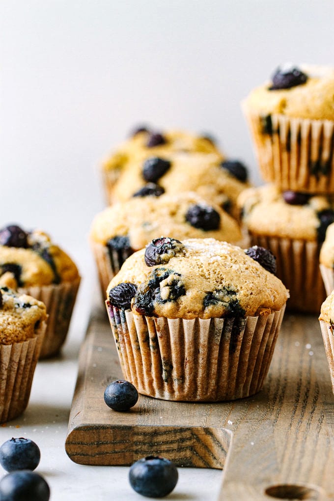 head on shot of vegan blueberry muffins on a wooden serving board.