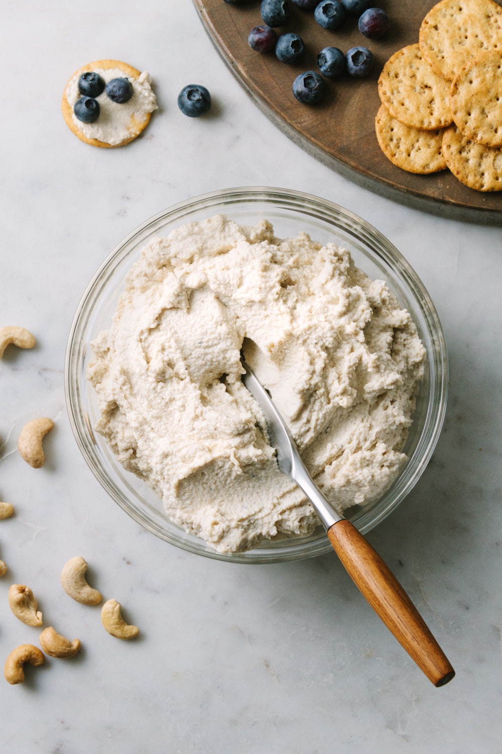 vegan cashew ricotta cheese in a bowl with wooden butter knife