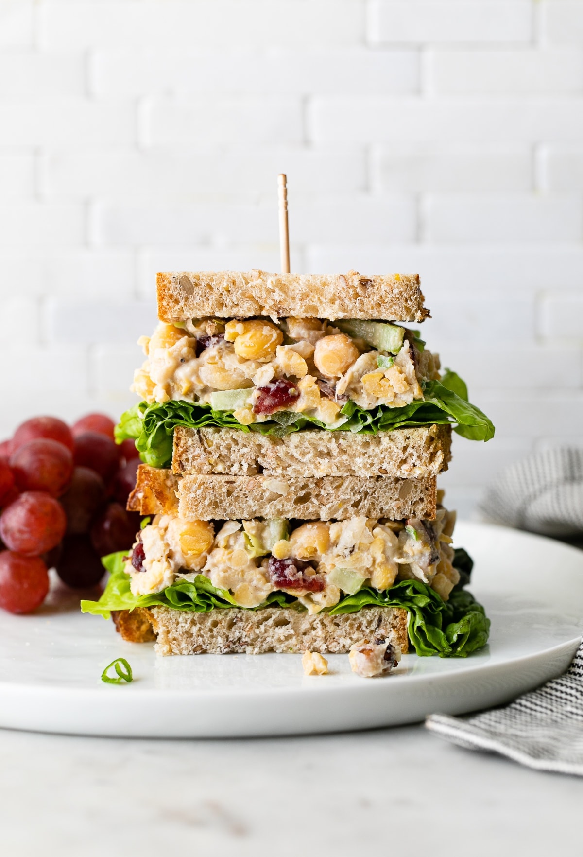 head on view of vegan chicken salad sandwich cut in half and stacked.