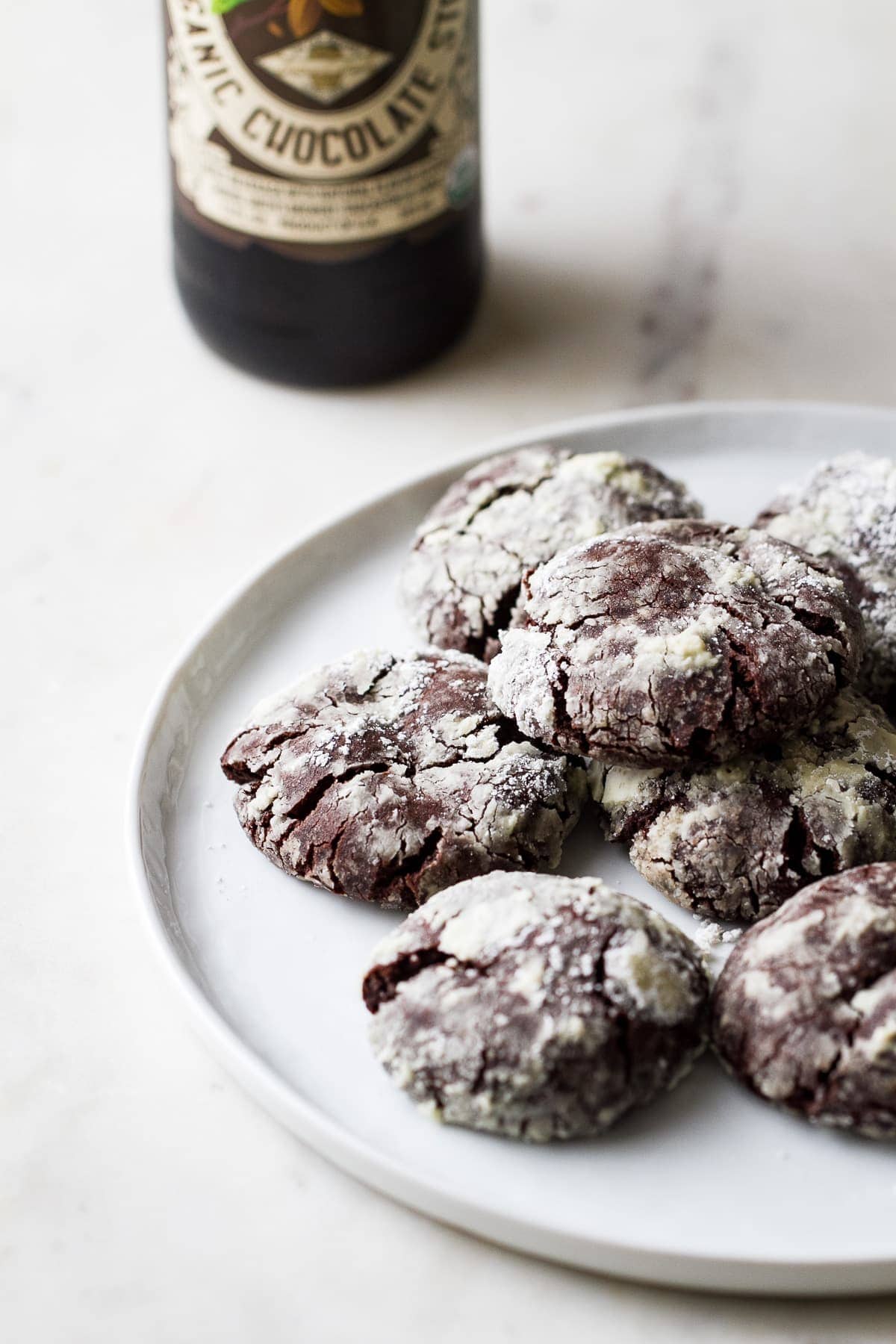 side angle view of vegan chocolate stout crinkle cookies on a plate.