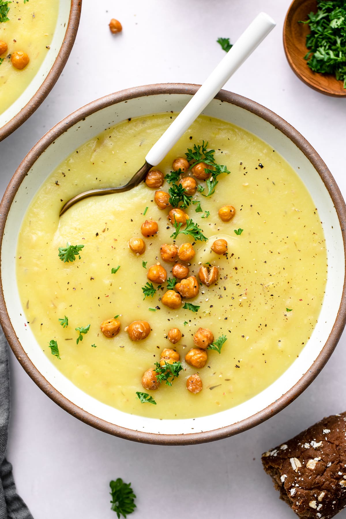 top down view of creamy vegan potato leek soup in a bowl with spoon.