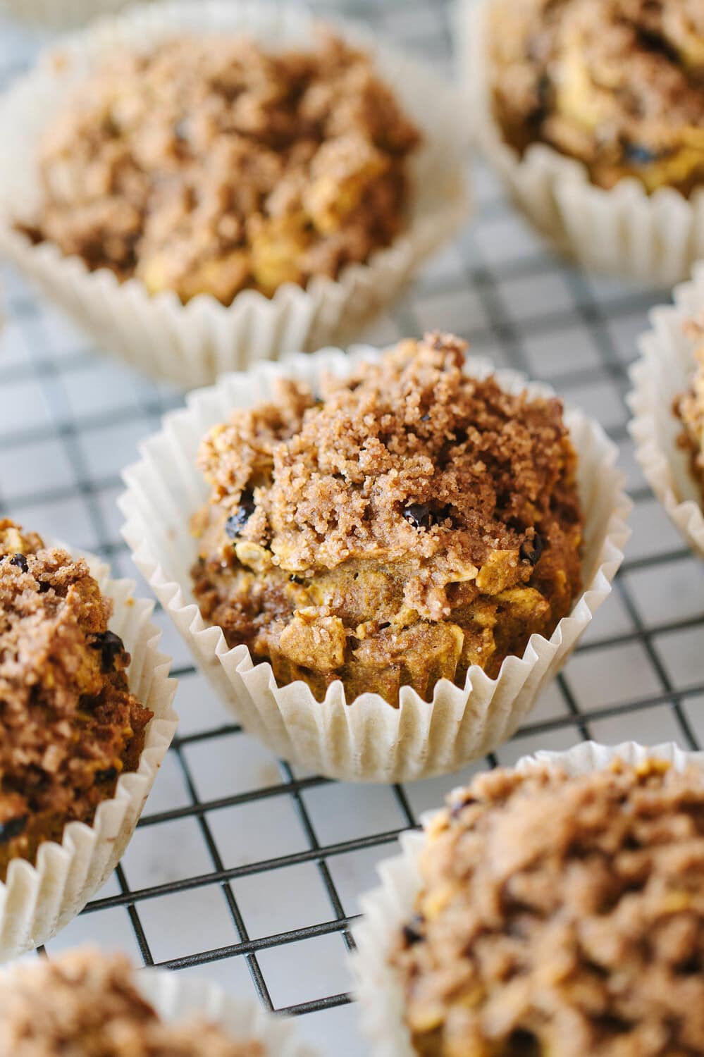 side angle view of freshly baked vegan pumpkin muffins cooling on a wire rack.