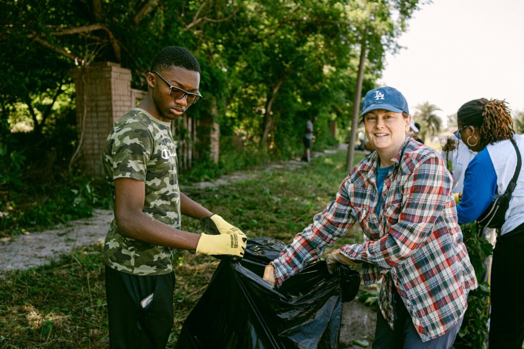 man and woman holding trash bag open